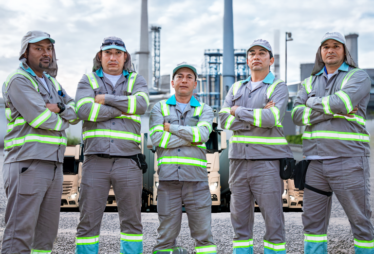 1. Equipo de trabajo con uniformes y elementos de protección personal en instalaciones industriales.