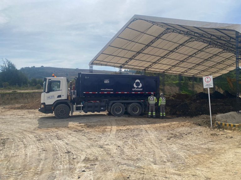 Camión y operarios en un área cubierta para el manejo de residuos orgánicos.